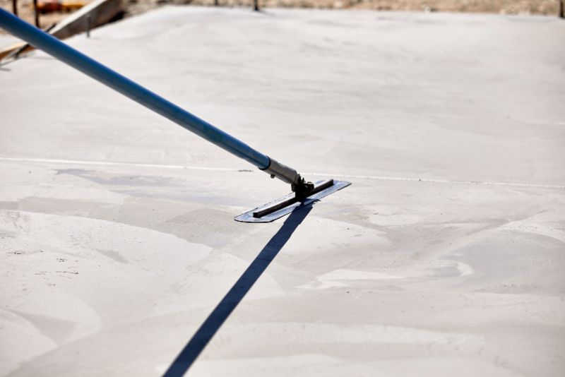 Concreter finishing a smooth concrete slab with a trowel in Bundaberg