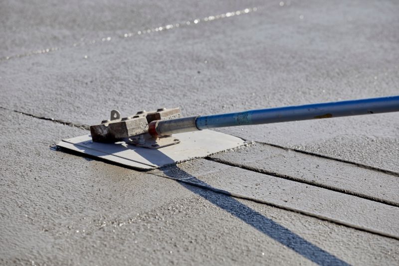 Textured pattern being stamped into wet concrete for a decorative finish